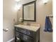Well-lit bathroom vanity featuring dark cabinetry, a granite countertop, and modern fixtures at 6660 E Floyd Ave, Denver, CO 80224