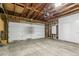 Unfinished garage featuring an electric garage door, concrete floor and a Tesla Powerwall at 6660 E Floyd Ave, Denver, CO 80224