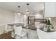 Bright kitchen featuring a breakfast bar, stainless steel appliances, white cabinetry, and hardwood flooring at 6660 E Floyd Ave, Denver, CO 80224
