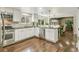 Bright kitchen featuring stainless steel appliances, white cabinetry, dark countertops, and hardwood flooring at 6660 E Floyd Ave, Denver, CO 80224