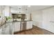 Bright kitchen featuring stainless steel appliances, white cabinetry, dark countertops, and hardwood flooring at 6660 E Floyd Ave, Denver, CO 80224