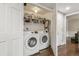 Efficient laundry room with washer, dryer, and storage shelves, conveniently located near the hallway at 6660 E Floyd Ave, Denver, CO 80224