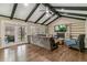 Living room with vaulted ceilings, dark wood beams, stone fireplace, built-ins, and natural light at 6660 E Floyd Ave, Denver, CO 80224