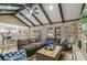 Open-concept living room with vaulted ceilings, dark wood beams, stone fireplace, built-ins, and natural light at 6660 E Floyd Ave, Denver, CO 80224