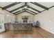 Inviting living room with vaulted ceilings, wooden beams, hardwood floors, and a cozy fireplace feature at 6660 E Floyd Ave, Denver, CO 80224
