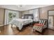 Bright main bedroom with hardwood flooring, a balcony view, and comfortable seating area at 6660 E Floyd Ave, Denver, CO 80224