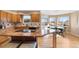 Eat-in kitchen with granite island, wood cabinets, and ample natural light at 15050 Harrison St, Brighton, CO 80602