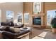 Living room features a sectional sofa, fireplace, and high ceilings at 15050 Harrison St, Brighton, CO 80602