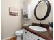 Clean powder room with updated vanity and oval mirror at 15050 Harrison St, Brighton, CO 80602