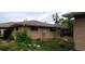 Back of house features brick exterior with some trees and overgrown grass and shrubbery at 2008 Moline St, Aurora, CO 80010