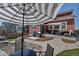 A spacious backyard patio features an outdoor dining area, seating, and a built-in grill with ample space for entertaining at 4840 Point Mesa St, Castle Rock, CO 80108