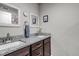 Bathroom with granite countertops, dual sinks, framed mirrors, and dark brown cabinets at 4840 Point Mesa St, Castle Rock, CO 80108