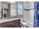 Bathroom with granite counters, wood cabinets, a window, and a shower-tub combo at 4840 Point Mesa St, Castle Rock, CO 80108