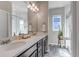 Bright bathroom featuring double sinks, quartz countertops, a step-in shower and wood-look floors at 4840 Point Mesa St, Castle Rock, CO 80108
