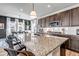 Granite countertop island in kitchen complemented by stainless steel appliances and stylish pendant lighting above at 4840 Point Mesa St, Castle Rock, CO 80108