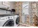 A stylish laundry room is decorated with floral wallpaper and includes a modern washer and dryer at 4840 Point Mesa St, Castle Rock, CO 80108