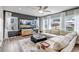 Bright living room with a large sectional sofa, modern entertainment center, and natural light from many windows at 4840 Point Mesa St, Castle Rock, CO 80108