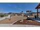 A community playground features slides, swings, and climbing structures set amidst natural landscaping and walking paths at 4840 Point Mesa St, Castle Rock, CO 80108