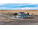 Expansive aerial view of the house, pastures, and pens against a beautiful distant mountain range at 52900 E 88Th Ave, Strasburg, CO 80136