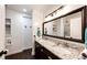 Modern bathroom features dual sinks, granite countertops, sleek dark wood vanity and a large framed mirror at 52900 E 88Th Ave, Strasburg, CO 80136