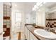 Tiled bathroom featuring double sinks with granite countertops at 52900 E 88Th Ave, Strasburg, CO 80136