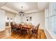 Dining room boasts a traditional table, wood floors, tray ceilings, and elegant light fixture at 52900 E 88Th Ave, Strasburg, CO 80136
