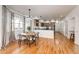 Open dining area with hardwood floors, stylish lighting, and adjacent modern kitchen at 52900 E 88Th Ave, Strasburg, CO 80136