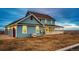 View of the back of the home with attached garage and large yard at 52900 E 88Th Ave, Strasburg, CO 80136