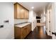 Hallway with light wood cabinets, granite countertop, and dark wood floors, leading to a living space at 52900 E 88Th Ave, Strasburg, CO 80136