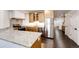 Well-lit kitchen with stainless steel appliances and granite countertops, adjacent to dark hardwood flooring at 52900 E 88Th Ave, Strasburg, CO 80136