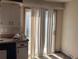 View of kitchen area leading to sliding doors, featuring white cabinets and laminate floors at 660 Hickory St, Hudson, CO 80642