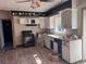 View of an outdated kitchen featuring laminate floors, white cabinets, and black appliances at 660 Hickory St, Hudson, CO 80642