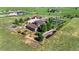 Aerial view of the property with a custom home, gardens, and outbuildings at 11784 Spruce Mountain Rd, Larkspur, CO 80118