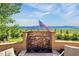 Inviting back patio with a stone water feature, American flag, and mountain views at 11784 Spruce Mountain Rd, Larkspur, CO 80118