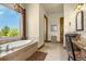 Bathroom featuring soaking tub, granite counters, vanity and dark wood cabinetry, and view from a large window at 11784 Spruce Mountain Rd, Larkspur, CO 80118