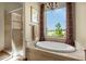 Soaking tub and glass shower with view from a large window with decorative curtains at 11784 Spruce Mountain Rd, Larkspur, CO 80118