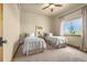 Bright, carpeted bedroom featuring two twin beds, a ceiling fan, and a scenic window view at 11784 Spruce Mountain Rd, Larkspur, CO 80118