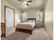 Bright bedroom with neutral colors, ceiling fan, ensuite door and comfortable queen bed at 11784 Spruce Mountain Rd, Larkspur, CO 80118
