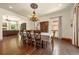 Elegant dining room featuring hardwood floors, a chandelier, and seamless transition into the living room at 11784 Spruce Mountain Rd, Larkspur, CO 80118