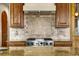 Gourmet kitchen with stainless steel range, custom tile backsplash, and granite countertops at 11784 Spruce Mountain Rd, Larkspur, CO 80118