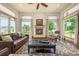Cozy living room featuring a fireplace, large windows with scenic views, and leather couches at 11784 Spruce Mountain Rd, Larkspur, CO 80118