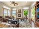 Bright living room featuring a fireplace, large windows with scenic views, and leather couches at 11784 Spruce Mountain Rd, Larkspur, CO 80118