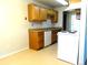 Well-lit kitchen featuring neutral countertops, tan tiled floors, and white appliances at 17331 E Mansfield Ave # 311L, Aurora, CO 80013