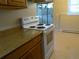 Bright kitchen featuring neutral countertop, standard white oven range, and tile flooring at 17331 E Mansfield Ave # 311L, Aurora, CO 80013