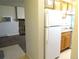 Kitchen transitioning into living area with white refrigerator, and stone fireplace at 17331 E Mansfield Ave # 311L, Aurora, CO 80013
