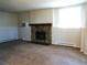 Carpeted living room featuring a stone fireplace, bright natural light, and neutral walls at 17331 E Mansfield Ave # 311L, Aurora, CO 80013