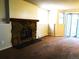 Carpeted living room showcasing stone fireplace, access to patio, and bright natural light at 17331 E Mansfield Ave # 311L, Aurora, CO 80013