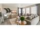 Modern living room with a gray sofa, large windows, stylish decor, and plenty of natural light at 3193 Belleville Ridge Rd, Elizabeth, CO 80107