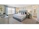 Serene primary bedroom with a tufted headboard, soft lighting, and a glimpse into the bathroom at 3193 Belleville Ridge Rd, Elizabeth, CO 80107