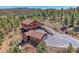 Aerial view of a charming home and detached garage on a sprawling, lush, tree-filled lot at 10786 Marclif Rd, Conifer, CO 80433